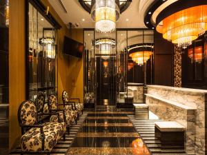 a lobby with a staircase with chairs and chandeliers at APA Hotel Iidabashi-Eki Minami in Tokyo