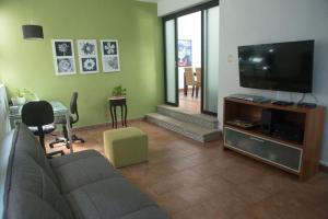 a living room with a couch and a flat screen tv at Cozy house downtown Cancun in Cancún