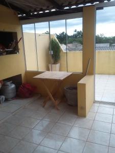 a room with a table and a large window at Apartamento amplo 300m da praia in São Lourenço do Sul