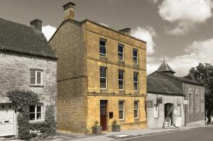 an old brick building on the side of a street at Victoria House in Stow on the Wold