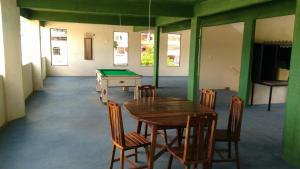 a room with a ping pong table and chairs with a pool table at Hotel Vitalle in Juiz de Fora