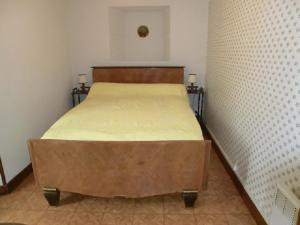 a bed in a small room with two lamps on the sides at Lou Filadour 1ère Etage 5 personnes in Jausiers