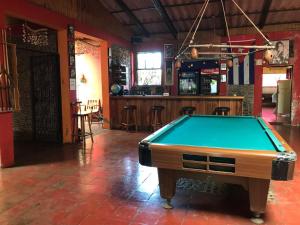 a pool table in a room with a bar at Hotel & Bar La Guitarra in El Sunzal