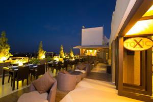 a restaurant with tables and chairs on a balcony at night at Hotel Atithi in Pondicherry