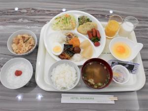 una bandeja de comida con arroz, huevos y bebidas en Hotel Nishimura en Fuji