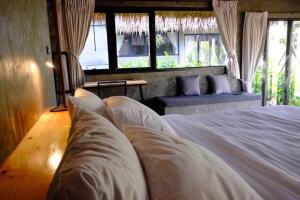 1 dormitorio con cama blanca y ventana en khaokho keree tara en Khao Kho