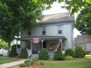 a blue house with an american flag on the porch at Black Lantern B&B in Topsham