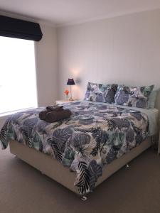 a bedroom with a large bed with a colorful blanket at Swansea Beach House Oceanfront in Swansea