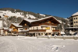 eine Ski-Lodge im Schnee mit schneebedecktem Boden in der Unterkunft Hotel Tristkogel in Saalbach-Hinterglemm
