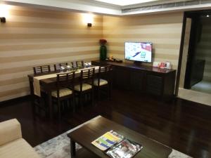 a living room with a bar with chairs and a television at Fortune Select Grand Ridge, Tirupati - Member ITC's Hotel Group in Tirupati