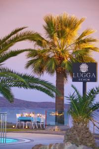 a table with chairs and a palm tree on the beach at Lugga Boutique Hotel & Beach in Ortakent