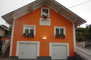 una casa naranja con dos puertas blancas de garaje en Gästehaus Daniela, en Schwanenstadt