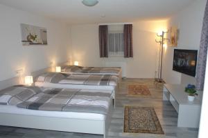 a room with three beds and a television and a room with at Gästehaus Daniela in Schwanenstadt