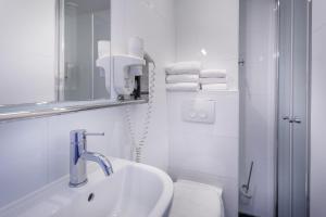 
a bathroom with a sink, toilet and bathtub at Hotel Victorie in Amsterdam
