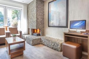 a living room with a couch and a fireplace at Hotel Victorie in Amsterdam