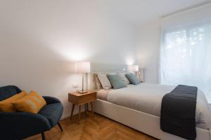 a bedroom with a bed and a chair and a window at Mila Apartments Via Savona in Milan