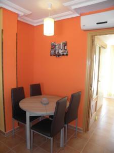 a dining room with orange walls and a table and chairs at Naturaleza y Golf in San Jorge