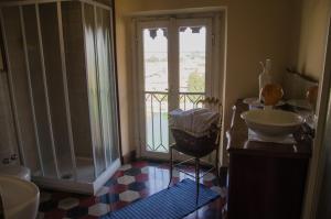a bathroom with a sink and a shower with a window at B&B La Finestra sul Fiume in Vaprio dʼAdda