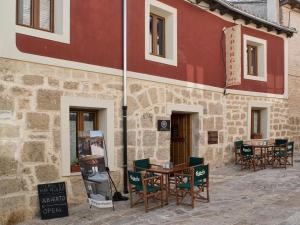 a building with a wooden table and chairs in front of it at aCienLeguas in Castrojeriz