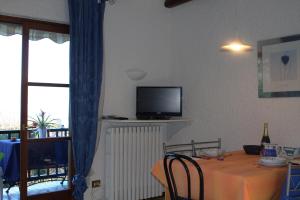 a dining room with a table and a tv on the wall at Casa Marica in Porto Valtravaglia