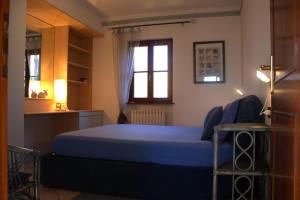 1 dormitorio con 1 cama azul y cocina en Casa Marica, en Porto Valtravaglia