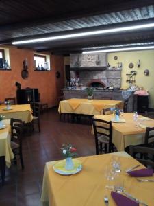 een restaurant met gele tafels en stoelen en een open haard bij Agriturismo San Martino in Castiglione Tinella