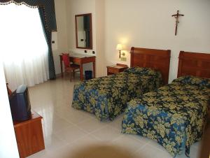 a hotel room with two beds and a tv at Hotel Centro di Spiritualità Padre Pio in San Giovanni Rotondo