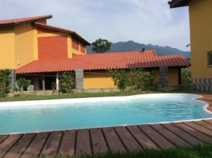a swimming pool in front of a house at Pousada Chalé na Roça Penedo in Penedo