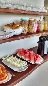 a table with plates of fruits and vegetables on plates at POUSADA Dunas de Marape - Alagoas in Jequia da Praia