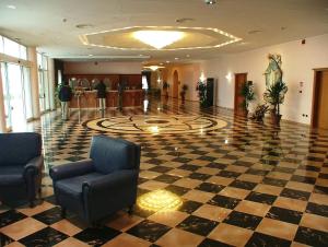 a lobby with a checkered floor and chairs in a building at Hotel Centro di Spiritualità Padre Pio in San Giovanni Rotondo