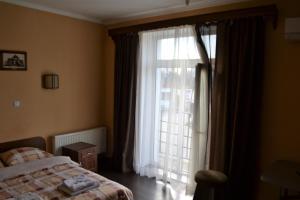 チェルニウツィーにあるKalinaのベッドルーム1室(ベッド1台、大きな窓付)