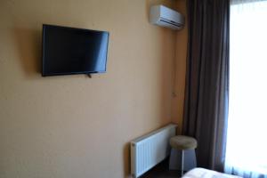 TV de pantalla plana en la pared de una habitación de hotel en Kalina, en Chernivtsi