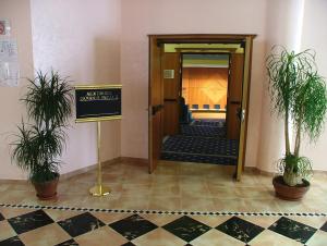a hallway with potted plants and a sign in a room at Hotel Centro di Spiritualità Padre Pio in San Giovanni Rotondo