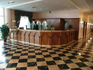 a man standing at a cash register in a lobby at Hotel Centro di Spiritualità Padre Pio in San Giovanni Rotondo