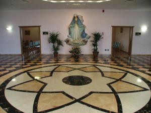 a lobby with a tiled floor with a picture on the wall at Hotel Centro di Spiritualità Padre Pio in San Giovanni Rotondo