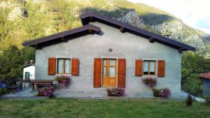 a small house with brown doors and a mountain at Chalet Abetone in Tuscany in Abetone