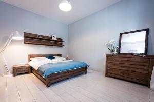 ein Schlafzimmer mit einem Bett, einem Spiegel und einer Kommode in der Unterkunft Stylowy apartament in Kattowitz