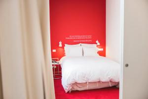 una camera con un letto bianco e una parete rossa di Smartflats - Pacific Brussels a Bruxelles