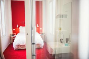 una camera da letto con pareti rosse, un letto e una vasca di Smartflats - Pacific Brussels a Bruxelles