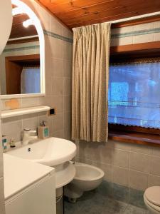 マドンナ・ディ・カンピリオにあるLiving Brenta Apartmentのバスルーム(洗面台、トイレ付)、窓が備わります。