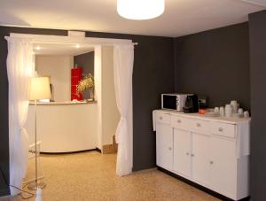 a room with a white cabinet and a microwave at Hotel Bosquemar in Benic&agrave;ssim