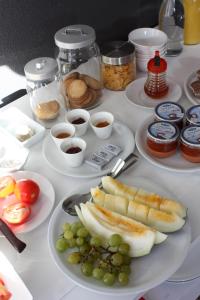a table filled with plates of food with fruits and condiments at Hotel Bosquemar in Benic&agrave;ssim