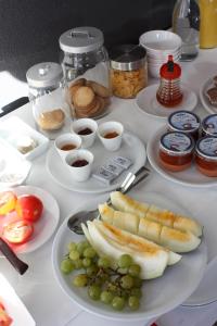 a table filled with plates of food with fruits and condiments at Hotel Bosquemar in Benicàssim