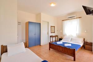 カト・ダラトソにあるKaterina Rooms Agii Apostoloiのベッドルーム1室(ベッド2台、青いキャビネット付)