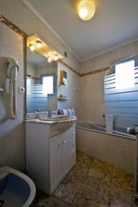 La salle de bains est pourvue d'un lavabo, d'une baignoire et d'un miroir. dans l'établissement Logis Hotel Restaurant Planes, à Saillagouse