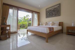een slaapkamer met een groot bed en een groot raam bij Yudha Ubud in Ubud