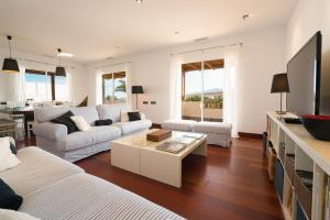 a living room with two couches and a table at Villa Dedalos - A luxury large villa with a heated pool in Puerto Calero in Puerto Calero