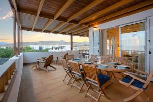 a dining room with a table and chairs on a balcony at Villa Dedalos - A luxury large villa with a heated pool in Puerto Calero in Puerto Calero