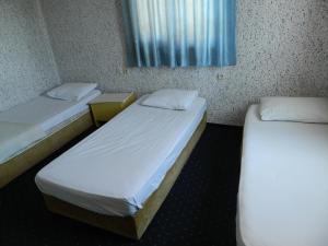2 łóżka w małym pokoju z oknem w obiekcie Sunrise Hotel w mieście Antalya