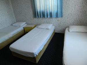 two beds in a small room with a window at Sunrise Hotel in Antalya